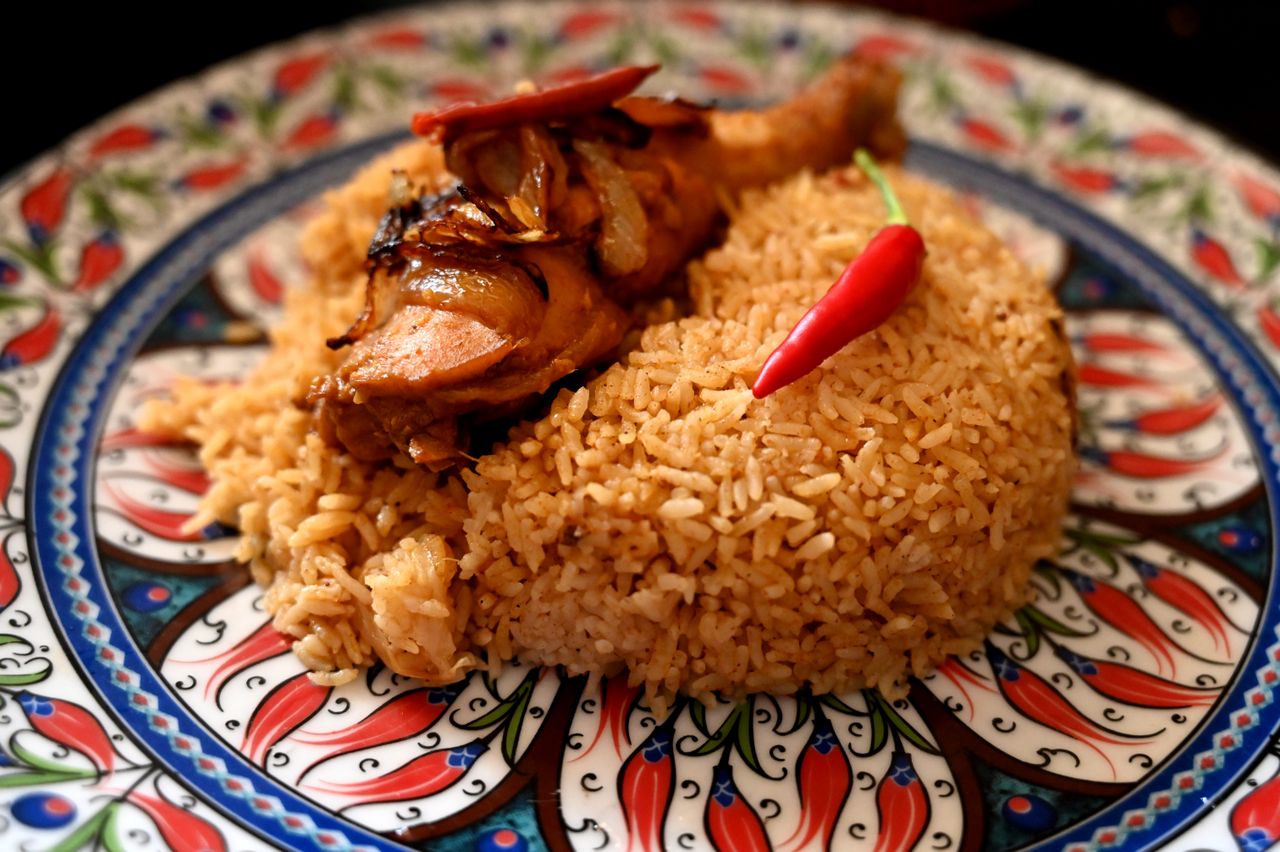 Services Close-up of chicken biryani with chili on a decorative plate from Chattogram.
